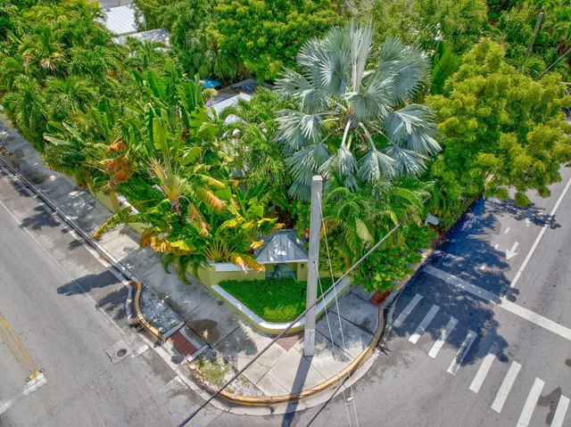 an outdoor sitting area with chairs and table under an umbrella
