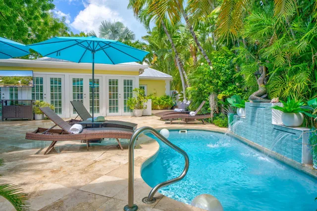 a view of a swimming pool with lounge chairs in patio