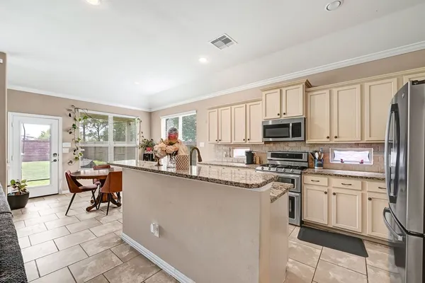 a kitchen with stainless steel appliances kitchen island granite countertop a sink and cabinets