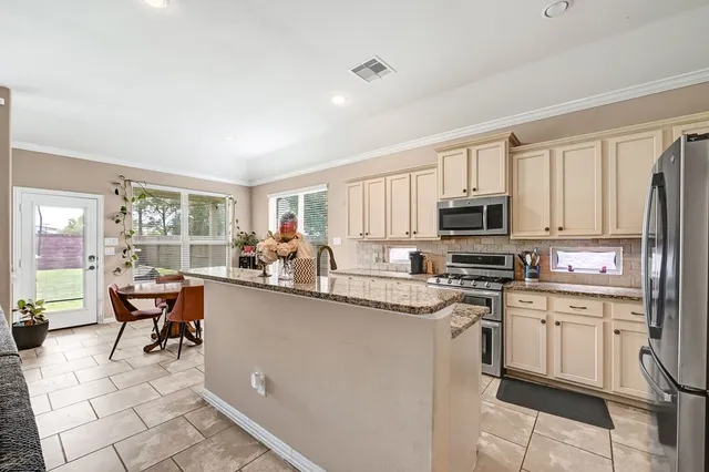 a kitchen with stainless steel appliances kitchen island granite countertop a sink and cabinets