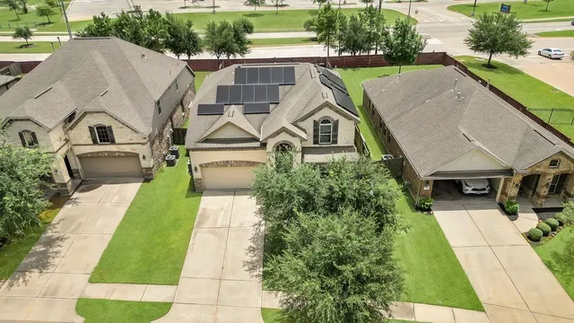 an aerial view of a house with swimming pool and patio