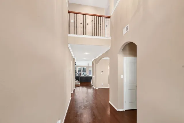 a view of a hallway with wooden floor and staircase