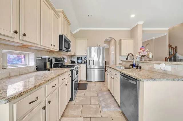 a kitchen with stainless steel appliances granite countertop a sink and dishwasher a stove with wooden floor