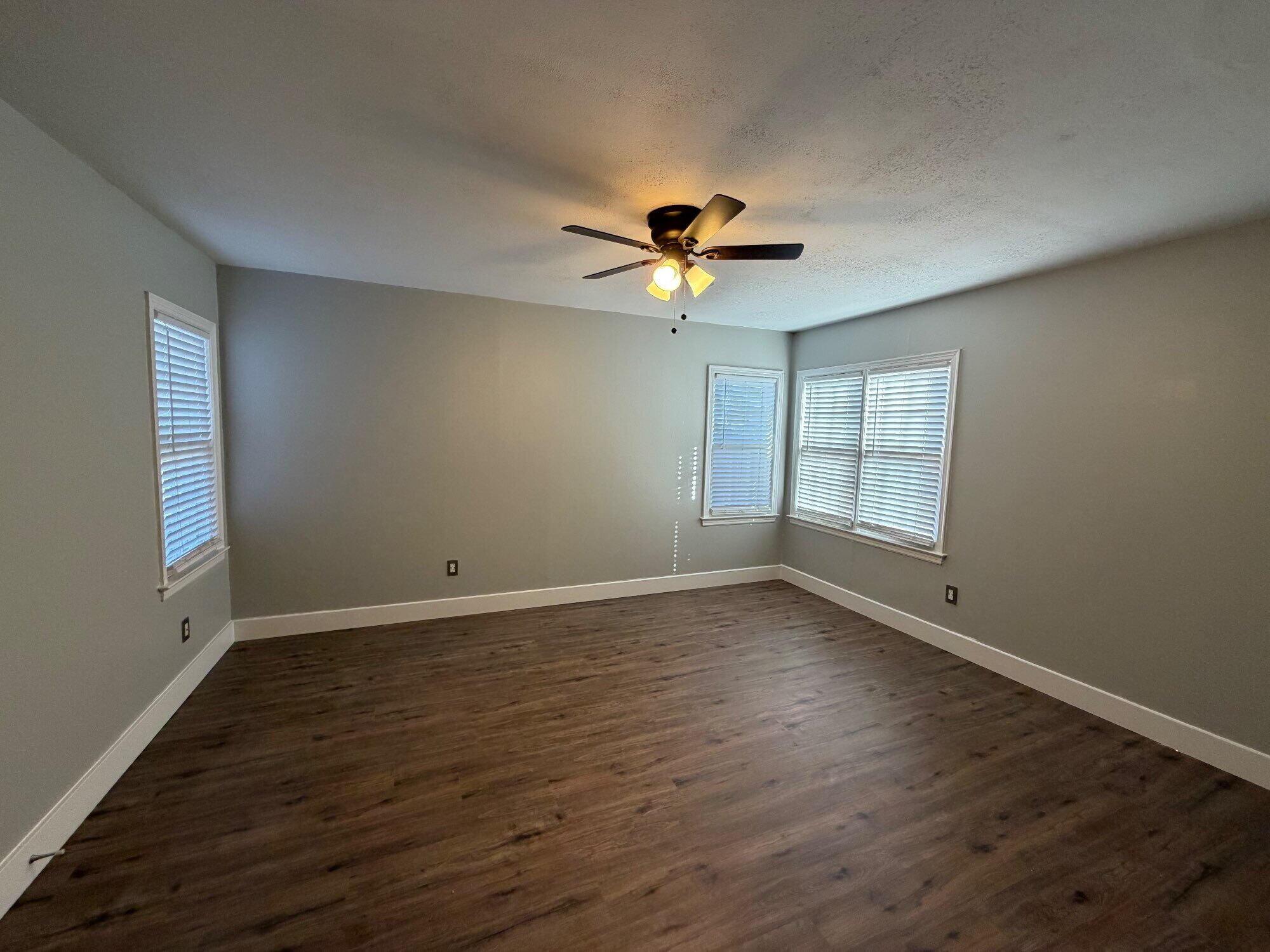2703 30th Street Lubbock, TX 79410 - Photo 11 of 15 a view of an empty room with a window and wooden floor