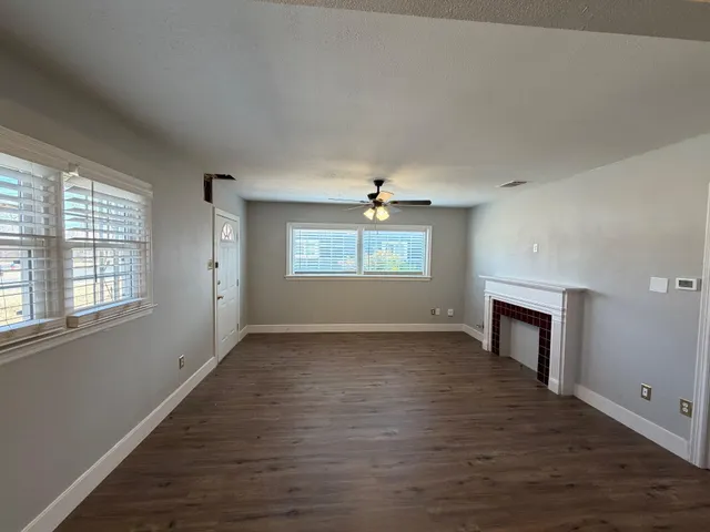 an empty room with windows and fireplace