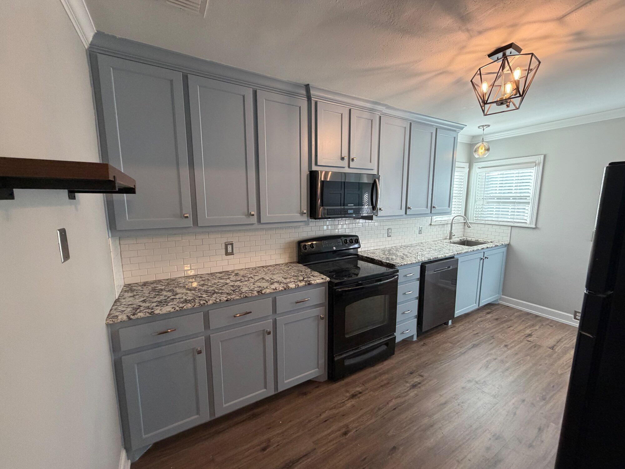 2703 30th Street Lubbock, TX 79410 - Photo 6 of 15 a kitchen with a sink stove and cabinets