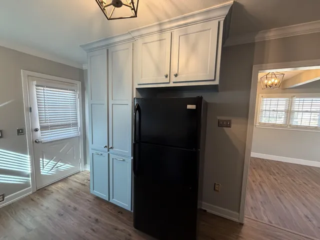 a view of a kitchen with wooden floor and a window