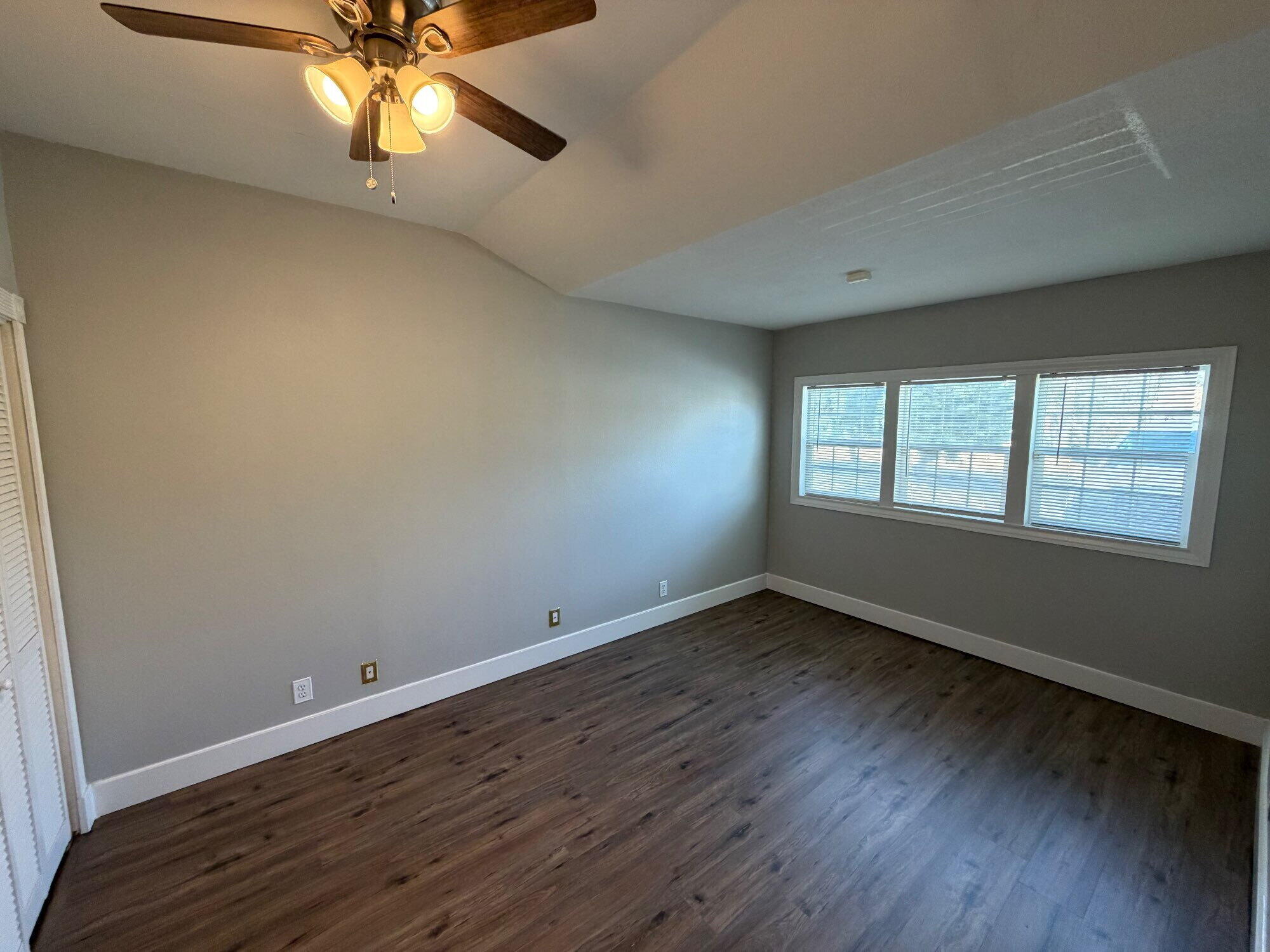 2703 30th Street Lubbock, TX 79410 - Photo 9 of 16 an empty room with wooden floor fan and windows