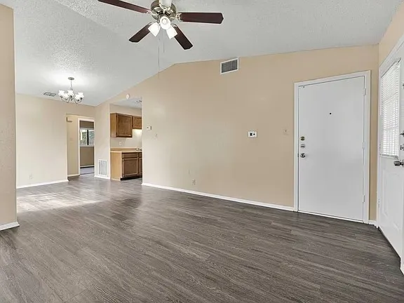 a view of a livingroom with a ceiling fan wooden floor and window