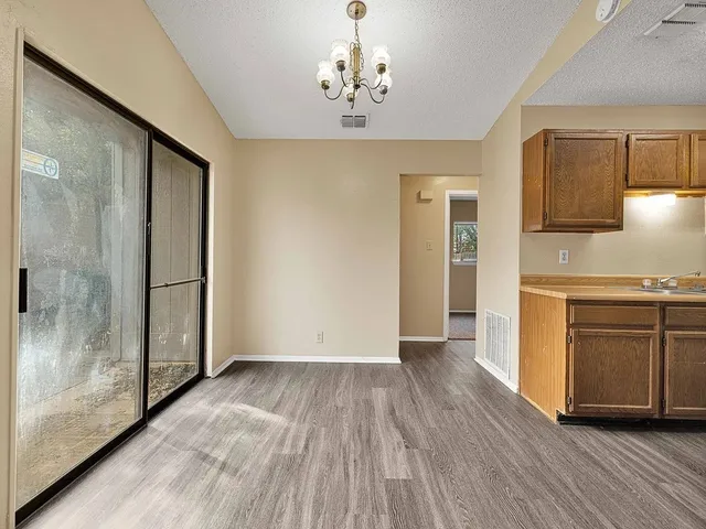 a view of a kitchen with wooden floor and a ceiling fan