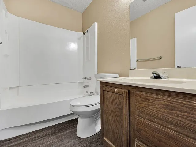 a bathroom with a sink a toilet and a large mirror