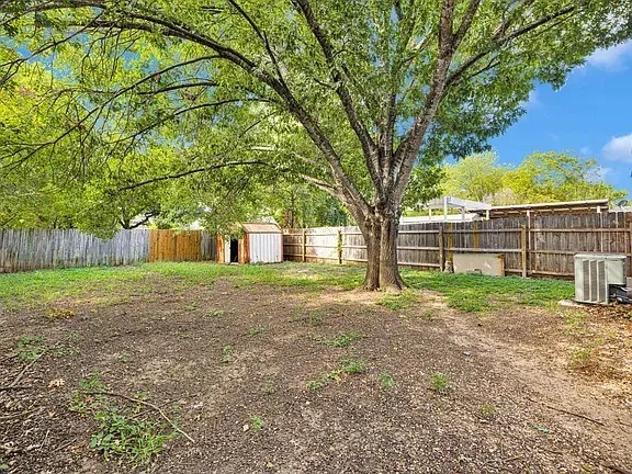 a view of a yard with a house and a large tree