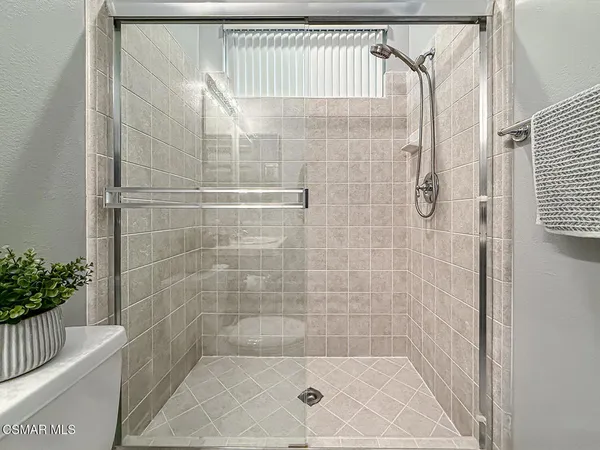 a bathroom with a granite countertop sink a toilet and shower