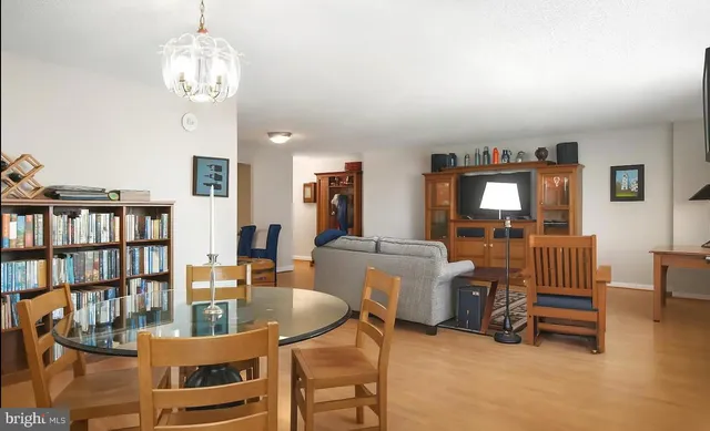 a living room with furniture a bookshelf and a chandelier
