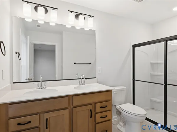 a bathroom with a double vanity sink mirror and toilet