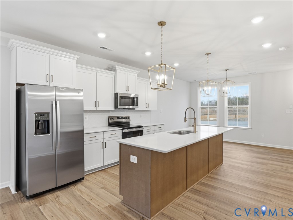 157 Corcoran Way Aylett, VA 23009 - Photo 2 of 22 a kitchen with stainless steel appliances kitchen island a sink a stove a refrigerator and cabinets