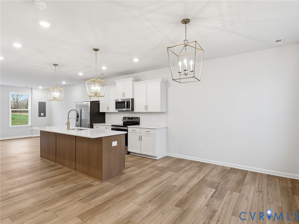 157 Corcoran Way Aylett, VA 23009 - Photo 7 of 22 a large white kitchen with wooden floor and stainless steel appliances