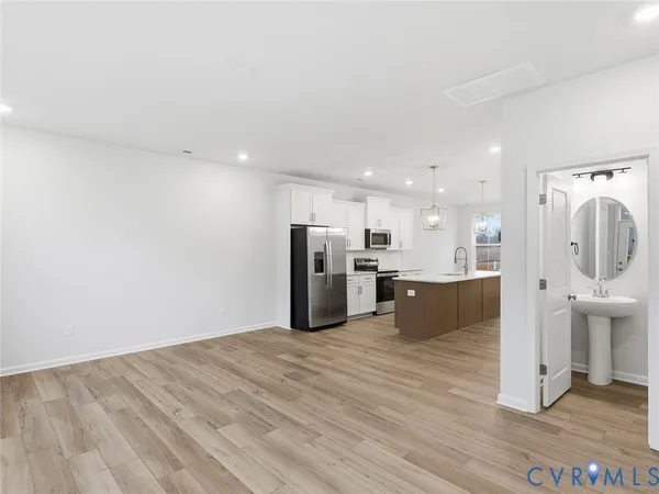 a kitchen with stainless steel appliances kitchen island granite countertop a refrigerator and a sink