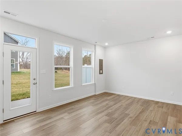 an empty room with wooden floor and windows