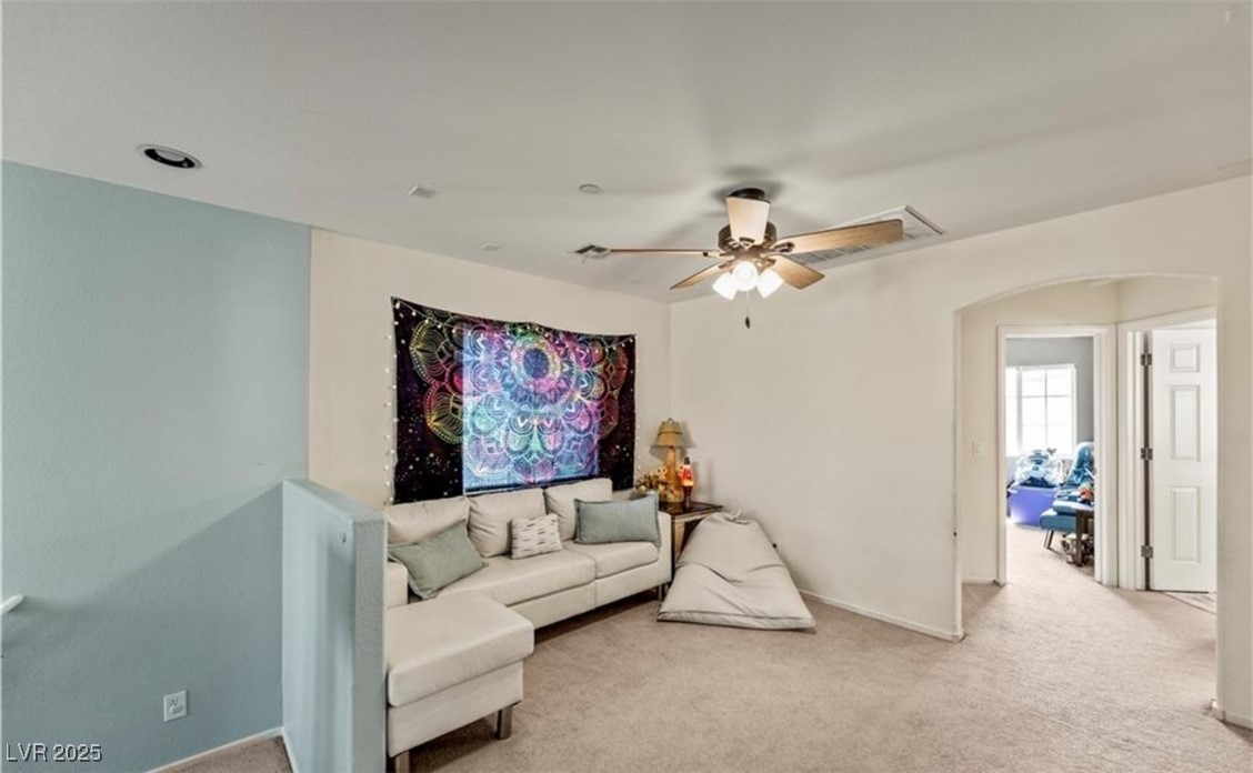 7708 Custom Weave Court Las Vegas, NV 89149 - Photo 16 of 32 Living room with arched walkways, carpet, and a ceiling fan