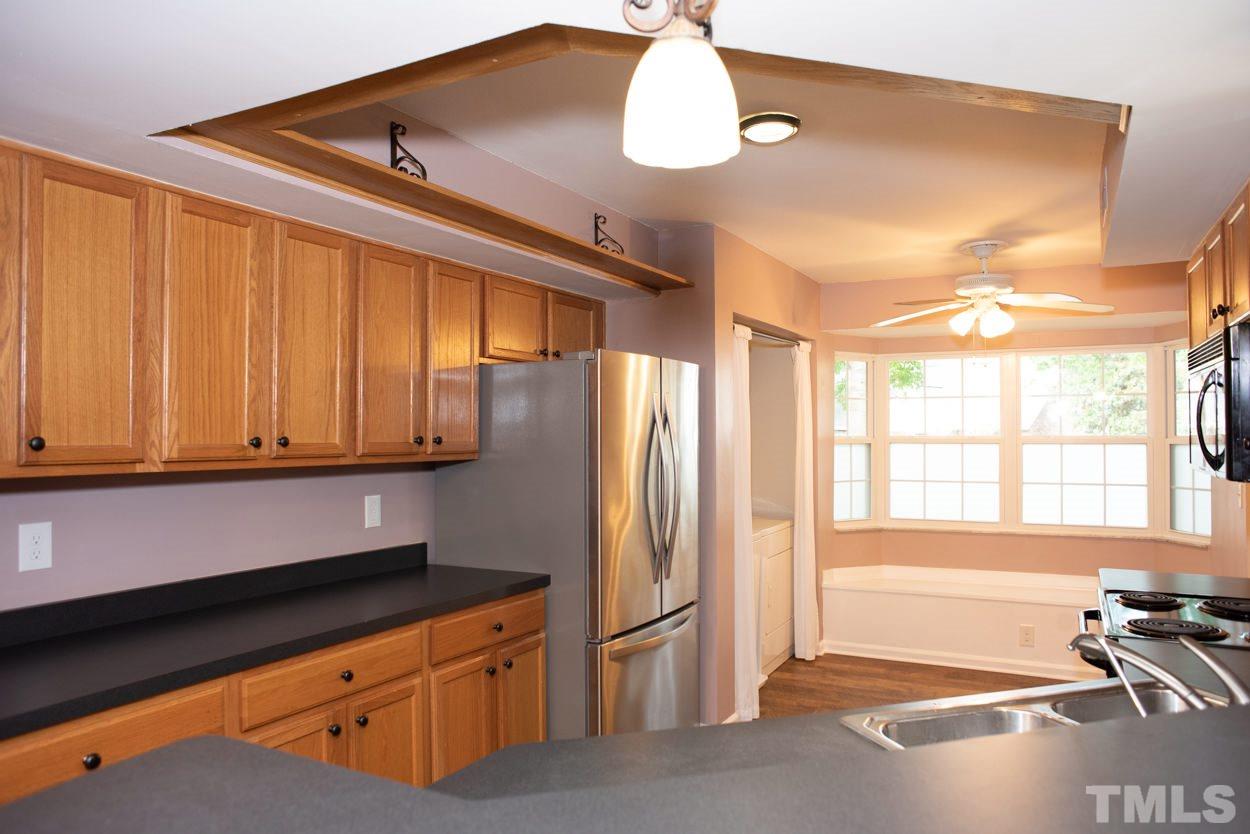 7933 Falcon Rest Circle, Unit 7933 Raleigh, NC 27615 - Photo 8 of 28 a kitchen with stainless steel appliances granite countertop a refrigerator and a stove top oven