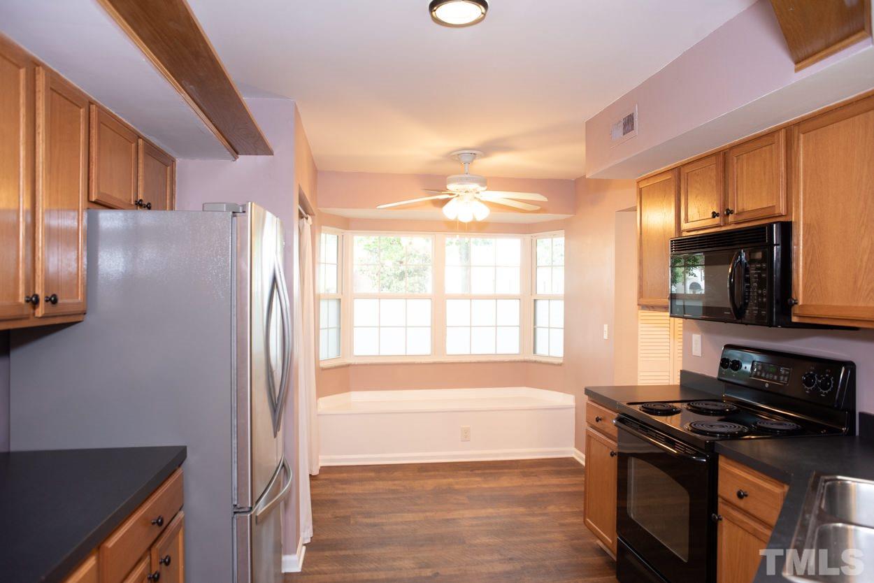 7933 Falcon Rest Circle, Unit 7933 Raleigh, NC 27615 - Photo 9 of 28 a kitchen with stainless steel appliances granite countertop a stove a sink and a microwave