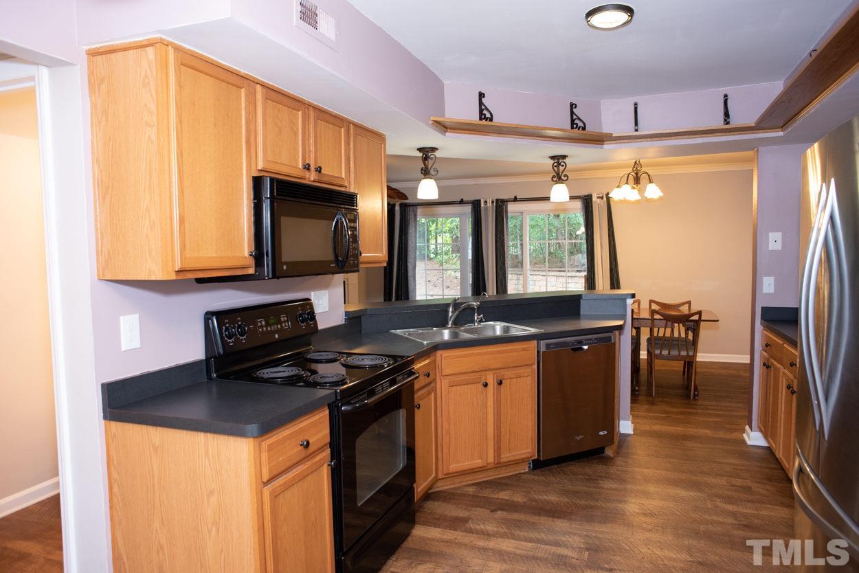 7933 Falcon Rest Circle, Unit 7933 Raleigh, NC 27615 - Photo 10 of 28 a kitchen with stainless steel appliances granite countertop a stove a sink dishwasher and a microwave oven with cabinets