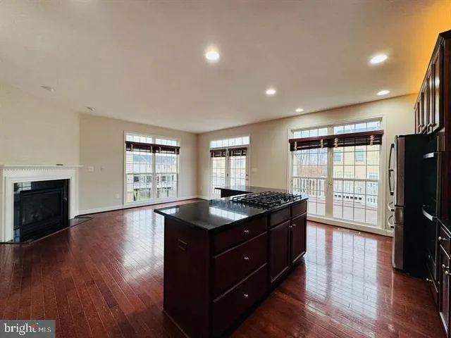 a kitchen with granite countertop a stove and a wooden floor