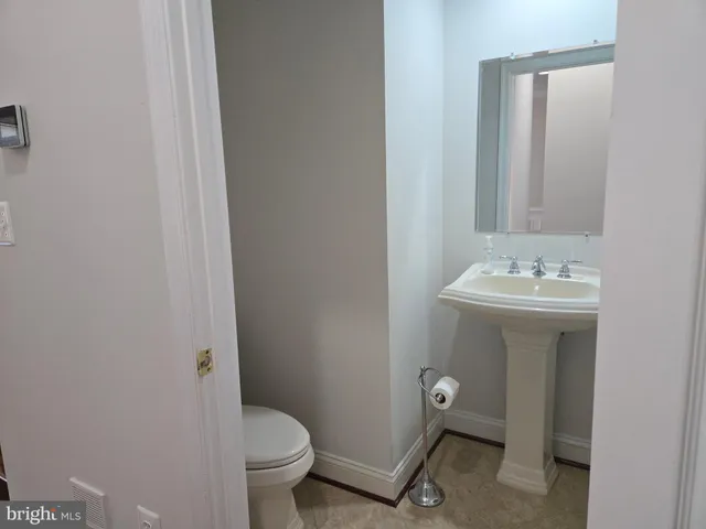 a bathroom with a toilet sink and a mirror