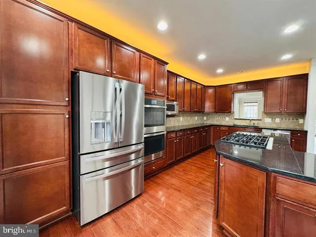 a kitchen with stainless steel appliances granite countertop a refrigerator stove and oven