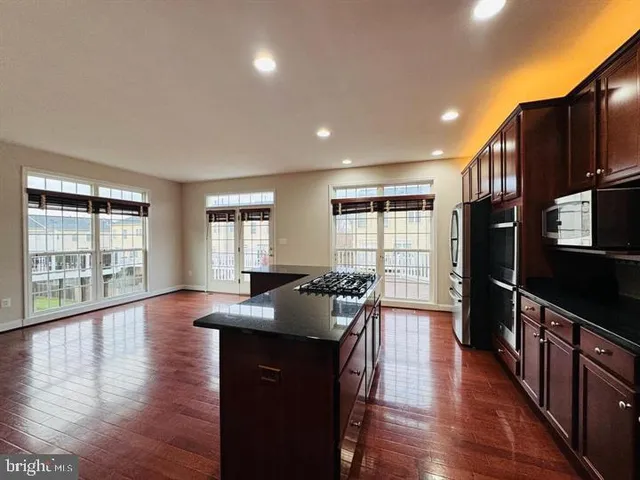 a kitchen with granite countertop a stove and wooden floor