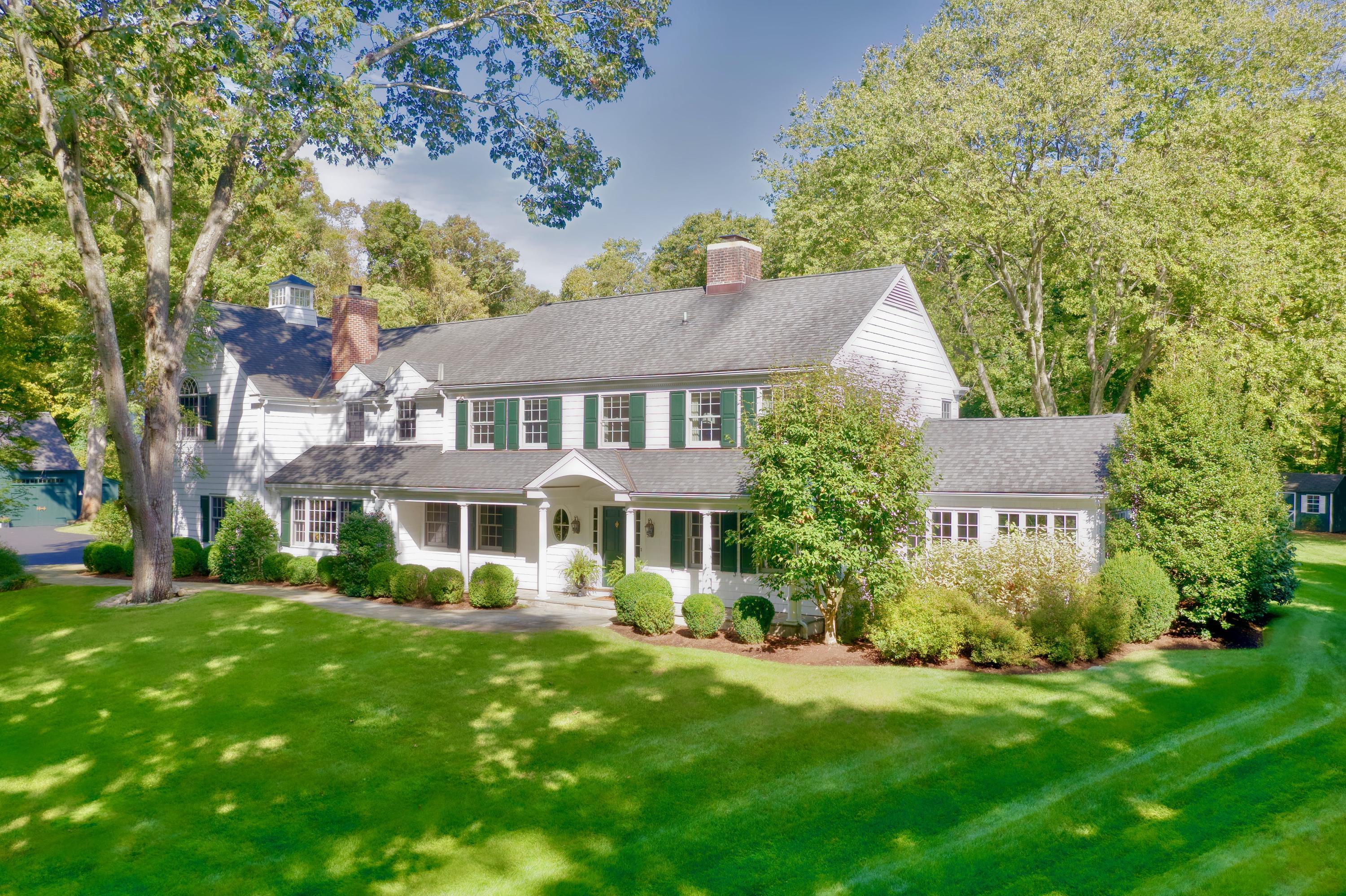 26 Beech Road New Canaan, CT 06840 - Photo 2 of 41 a front view of a house with a yard