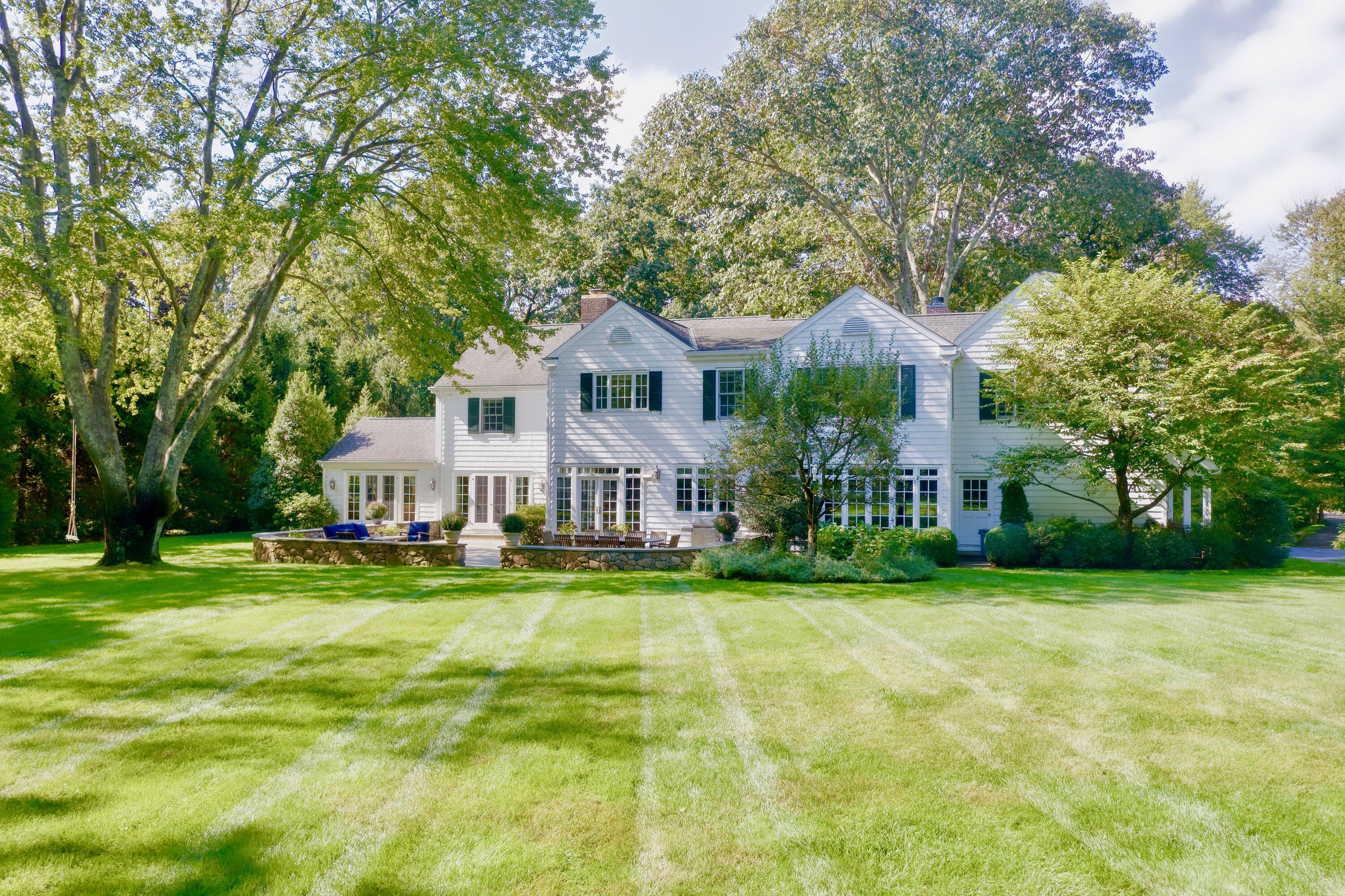 26 Beech Road New Canaan, CT 06840 - Photo 8 of 41 a front view of a house with a yard and trees