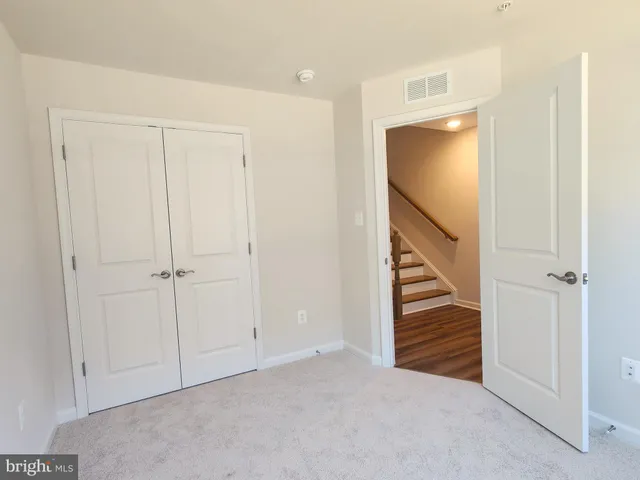 a view of a hallway with wooden floor and stairs