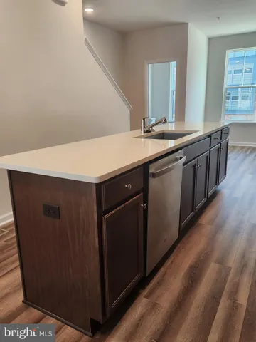 a kitchen with a sink cabinets and wooden floor