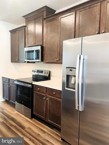 a kitchen with stainless steel appliances granite countertop a refrigerator and a stove