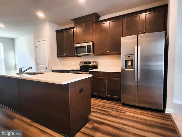 a kitchen with a sink refrigerator and microwave