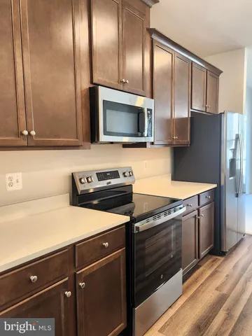 a kitchen with granite countertop cabinets stainless steel appliances and wooden floor