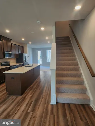 a large kitchen with wooden floors and stainless steel appliances