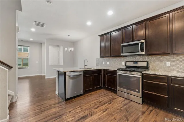 a kitchen with stainless steel appliances granite countertop a stove top oven microwave and cabinets