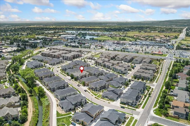 an aerial view of a residential houses with outdoor space and a lake view