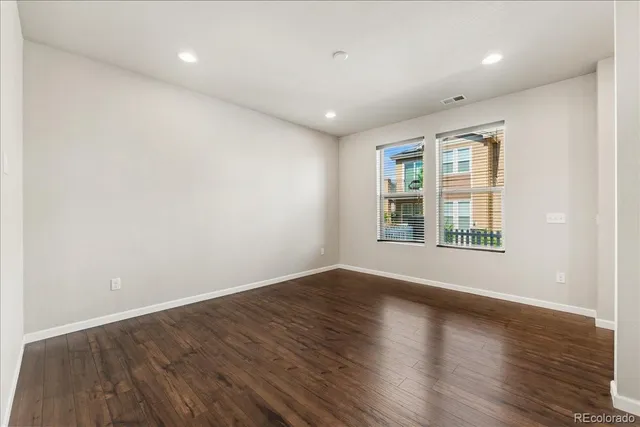 a view of kitchen with kitchen island a sink wooden floor and a refrigerator
