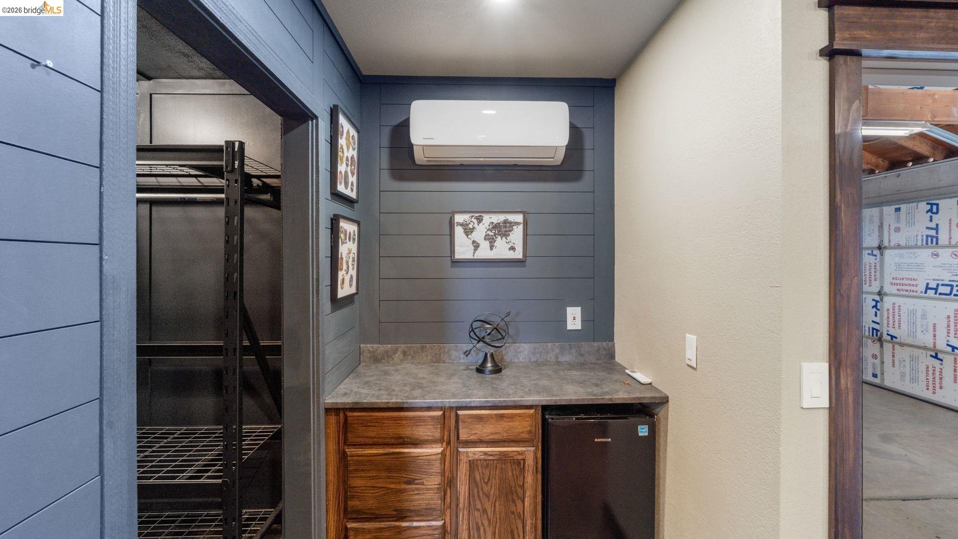 700 Brownstone Road Oakley, CA 94561 - Photo 51 of 58 Built-in cabinetry with a dark countertop, integrated compact refrigerator, and wall-mounted climate control unit