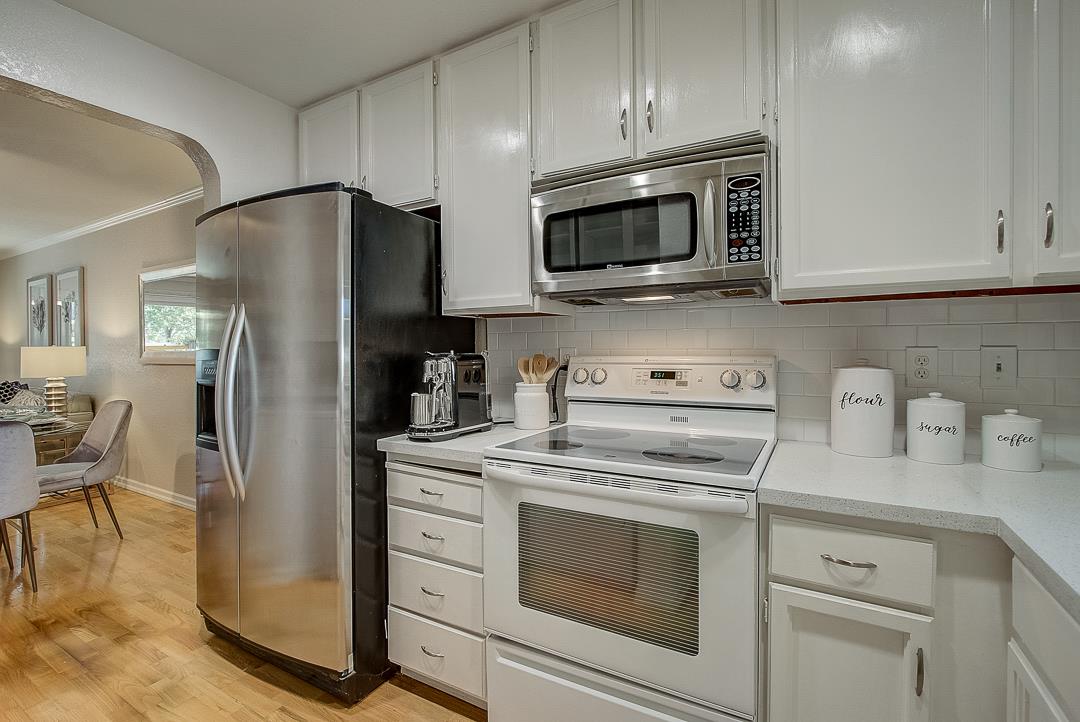 1303 Victoria Terrace Sunnyvale, CA 94087 - Photo 7 of 27 a kitchen with stainless steel appliances granite countertop white cabinets a refrigerator and a stove top oven