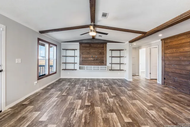 a view of an empty room with a window and fireplace