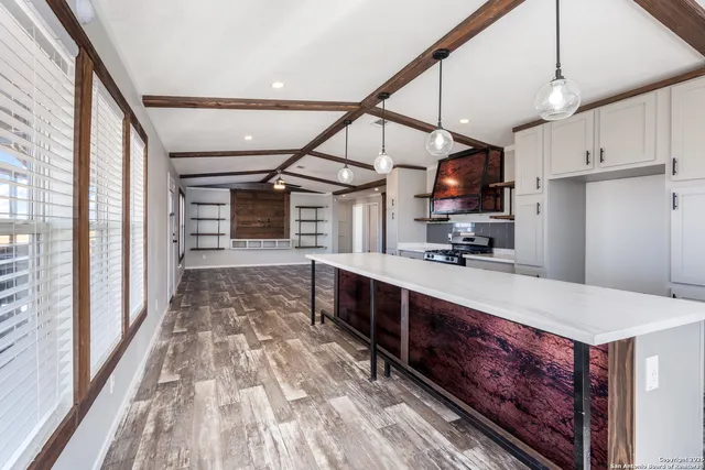 a large kitchen with stainless steel appliances granite countertop a large counter top a sink and cabinets