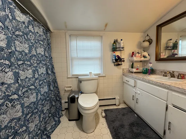 a bathroom with a toilet and a shower curtain