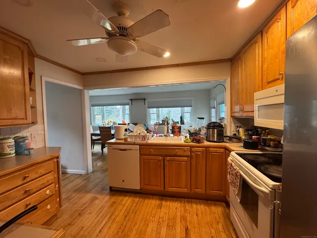 a kitchen with stainless steel appliances granite countertop a sink cabinets and wooden floor