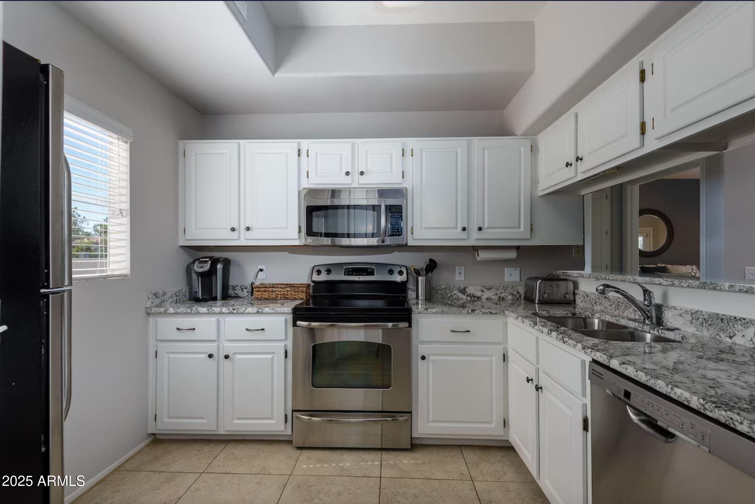 600 West Grove Parkway Tempe, AZ 85283 - Photo 11 of 23 a kitchen with cabinets appliances a sink and a counter top space