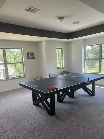 a room with furniture pool table and windows
